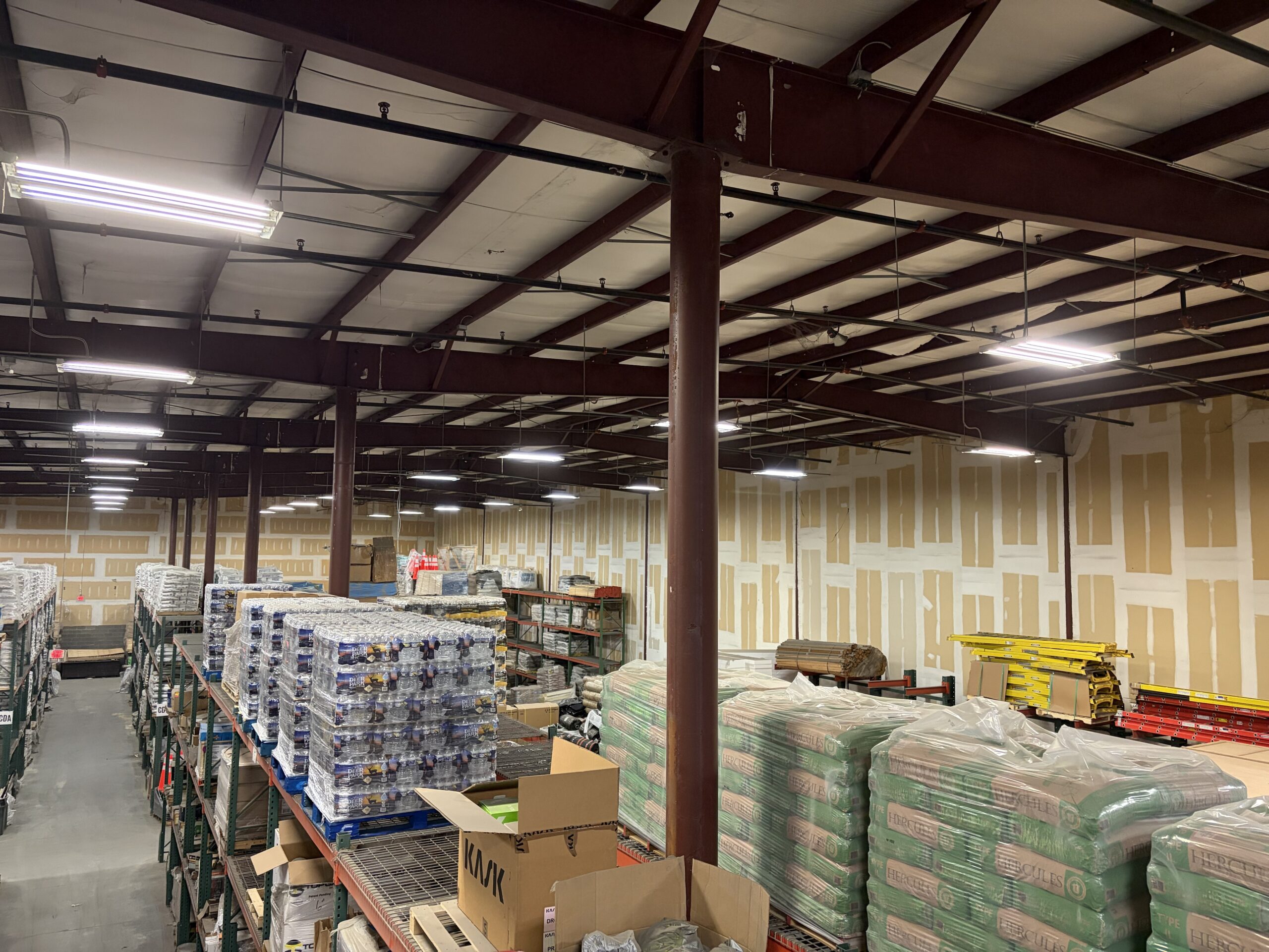 High-bay LED strip lighting installed in a commercial warehouse storage area by SparkWise Electric in Northern Virginia