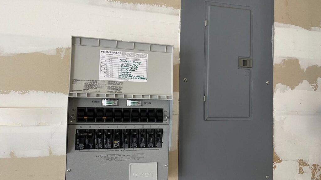 Generator transfer switch installed next to a main panel by SparkWise Electric in Northern Virginia.