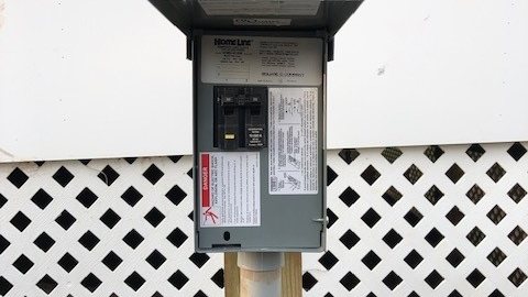 GFCI disconnect box mounted on wood post for hot tub electrical safety — NEC code compliant