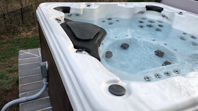 Hot tub spa with jets running on patio — SparkWise Electric installation