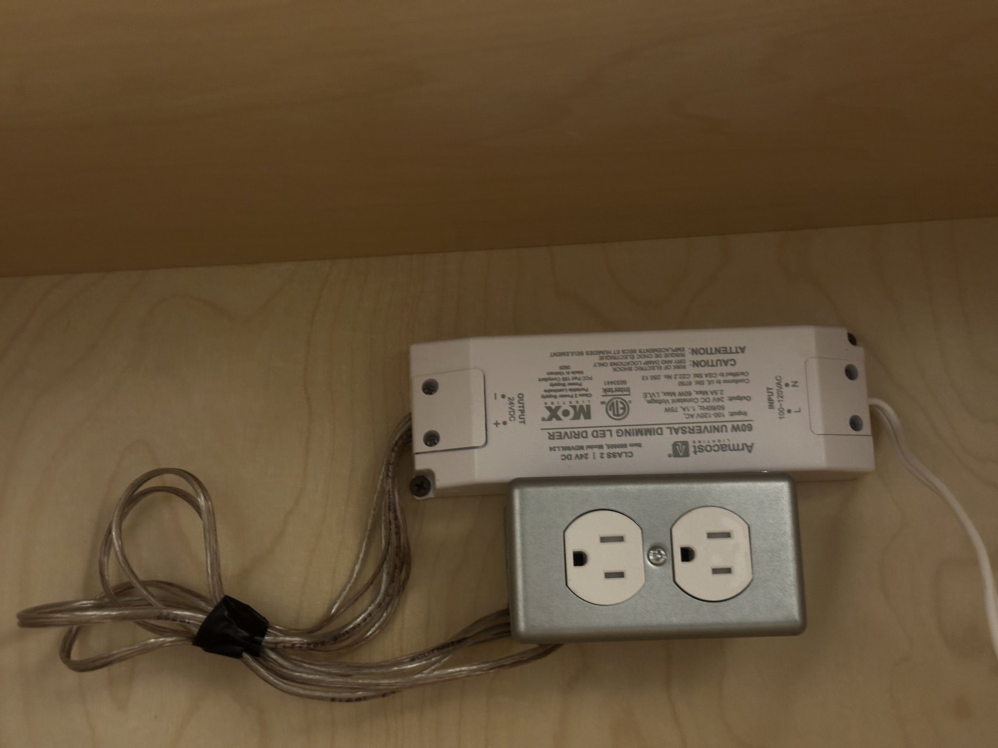 24-volt dimming LED driver mounted inside an upper cabinet next to a dedicated receptacle