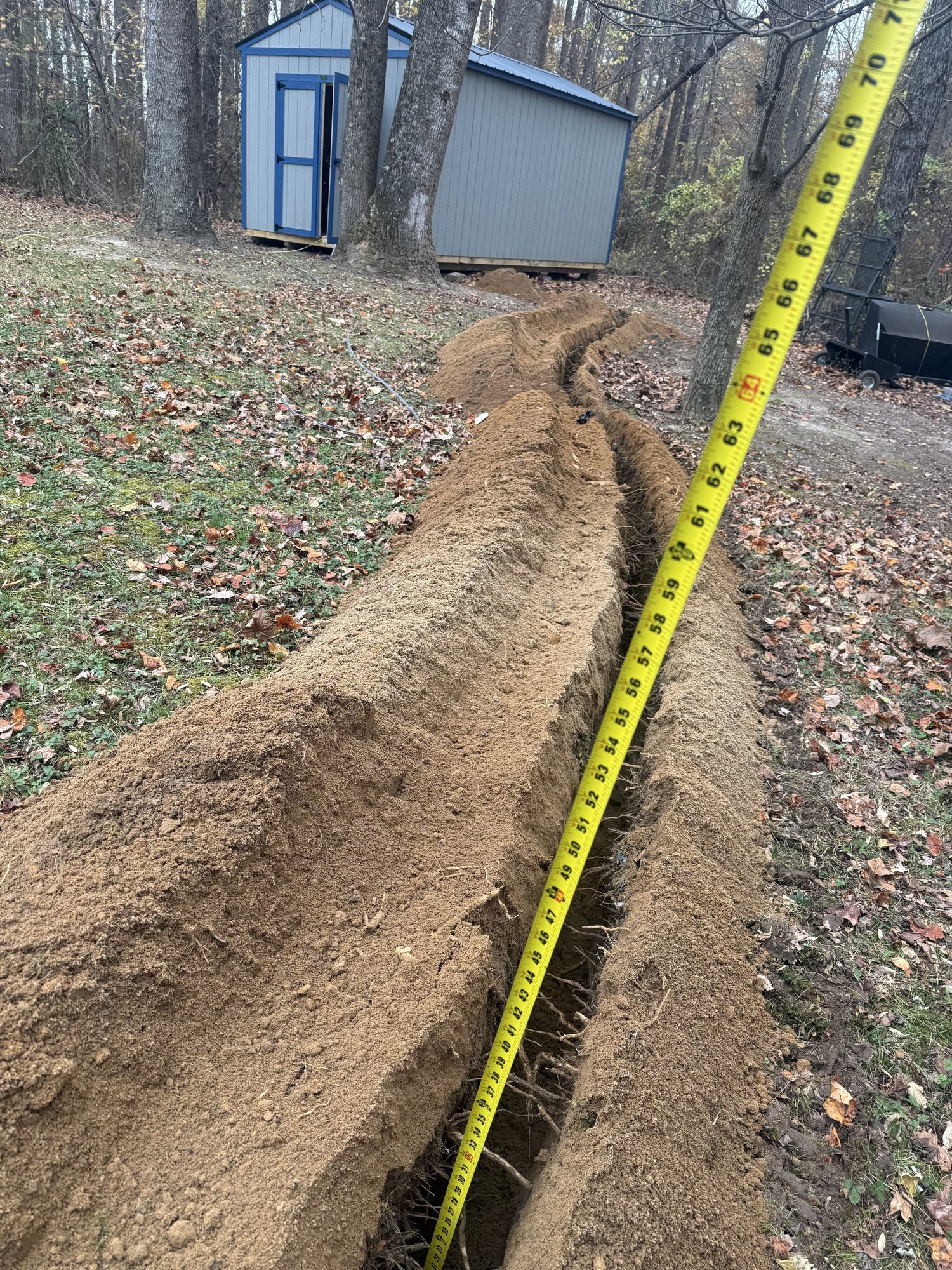 Open trench for an underground electrical feed running from a house to a backyard shed