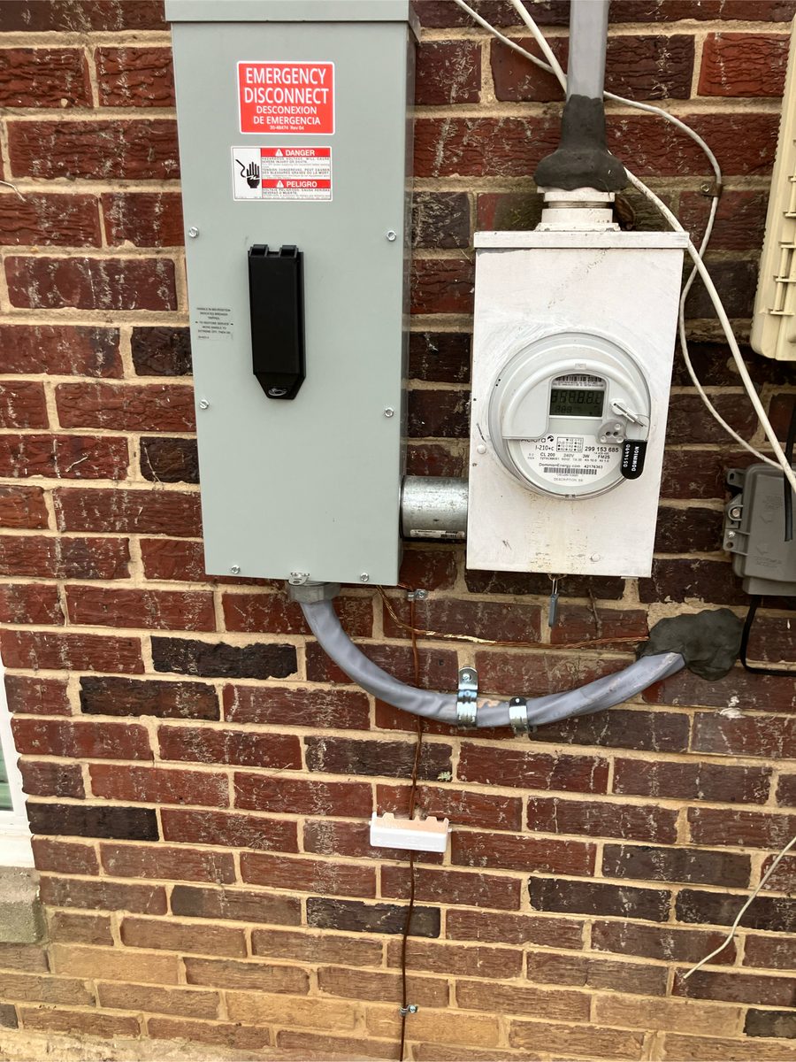 Exterior emergency disconnect and utility meter installed by SparkWise Electric