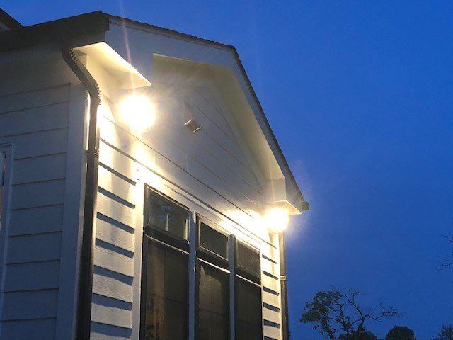 Gable-mounted exterior flood lighting installed on a home by SparkWise Electric