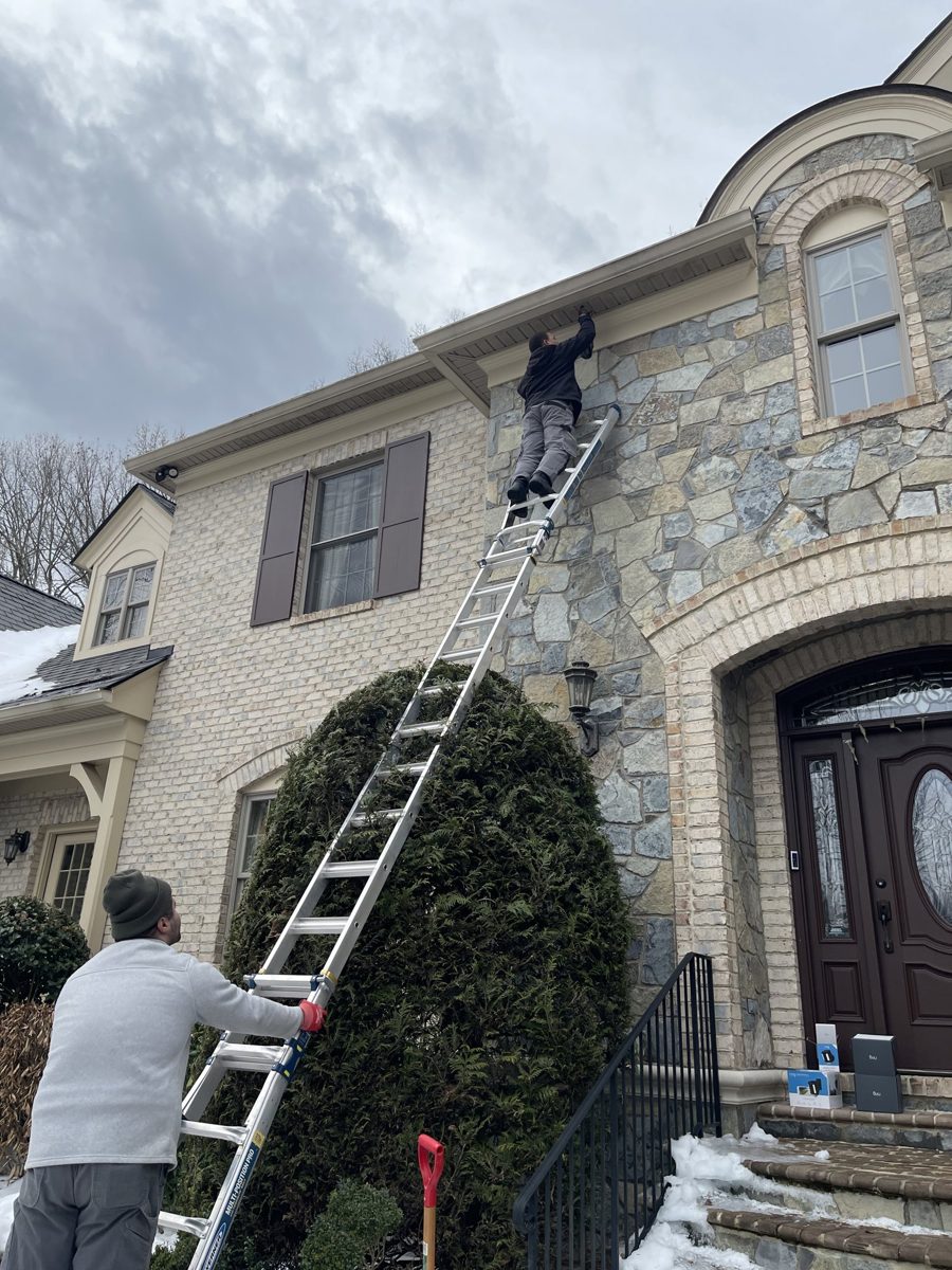 SparkWise Electric technicians installing exterior soffit lighting on a home