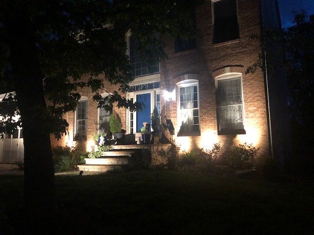 Facade and front-entry uplighting at dusk installed by SparkWise Electric in Northern Virginia