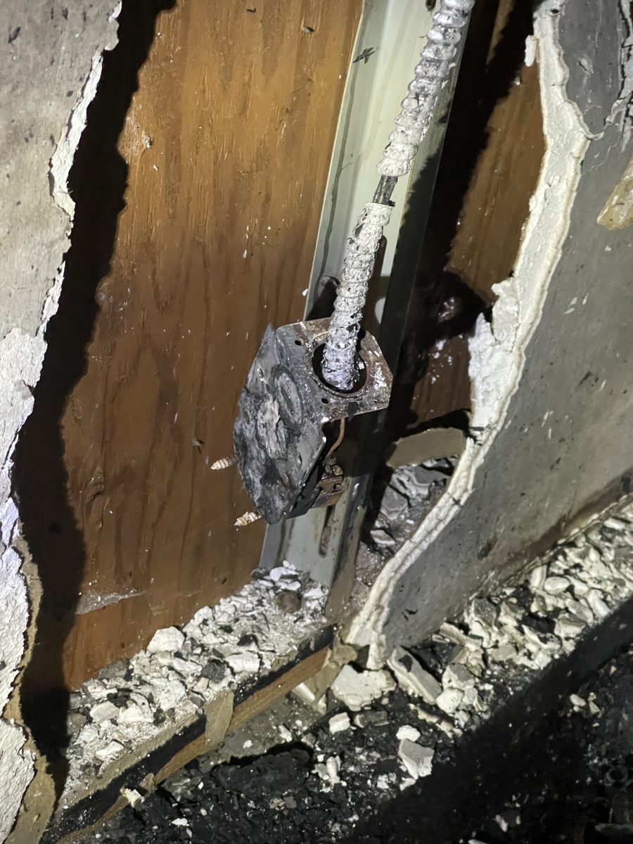 Burned junction box and charred conductors found during a garage fire damage survey by SparkWise Electric