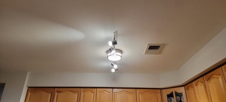 Track lighting fixture installed above kitchen cabinets by SparkWise Electric